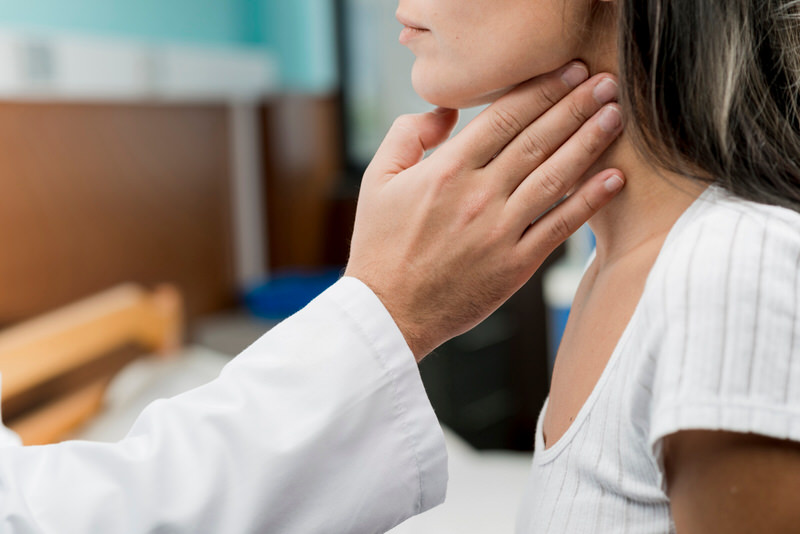 A young woman is at her checkup appointment after her recent thyroid surgery