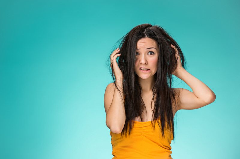 Frustrated young woman having a bad hair, wondering if her scalp is causing bad hair growth.