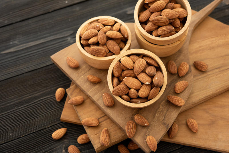 A few bowls of almonds sitting on a table.