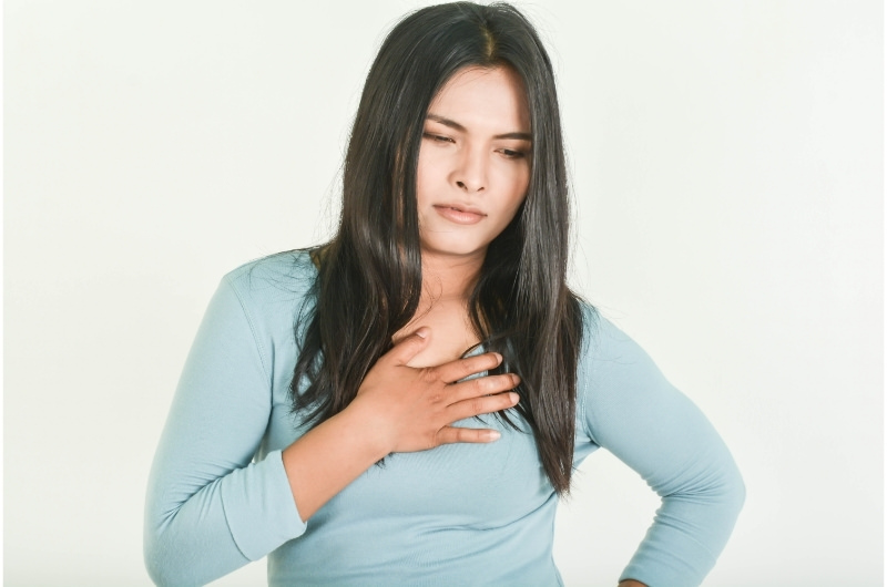 A young woman is having heartburn pain after drinking coffee.