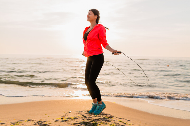 A woman jumping ropes by the beach as her daily exercise to burn calories.