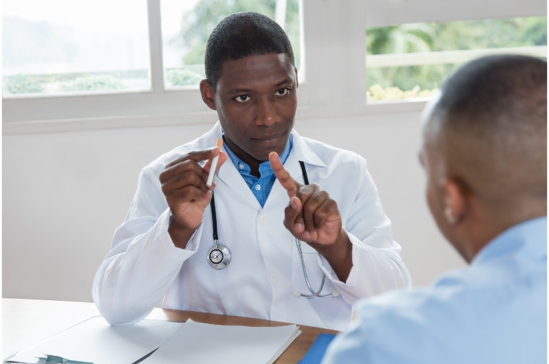 A doctor is telling his patient to stop smoking.