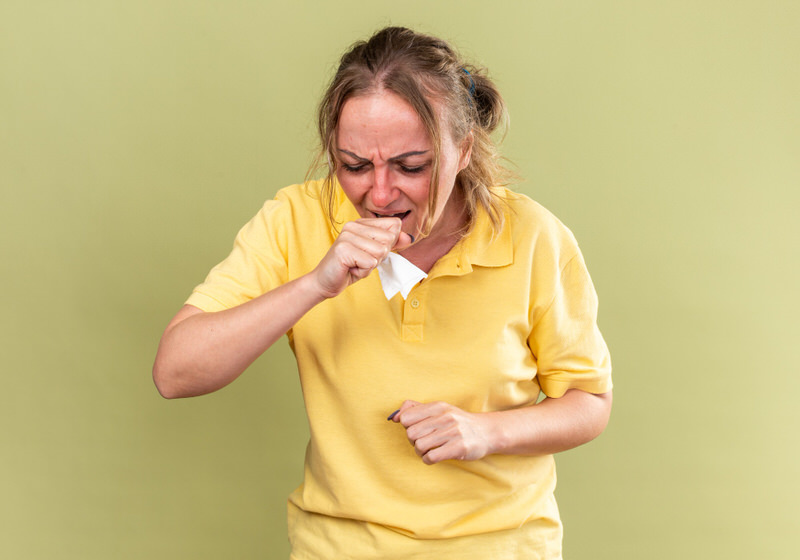 An unhealthy older woman is coughing a lot, possibly because of her smoking habits.
