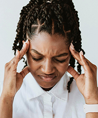 A young woman experiencing anxiety is rubbing her head