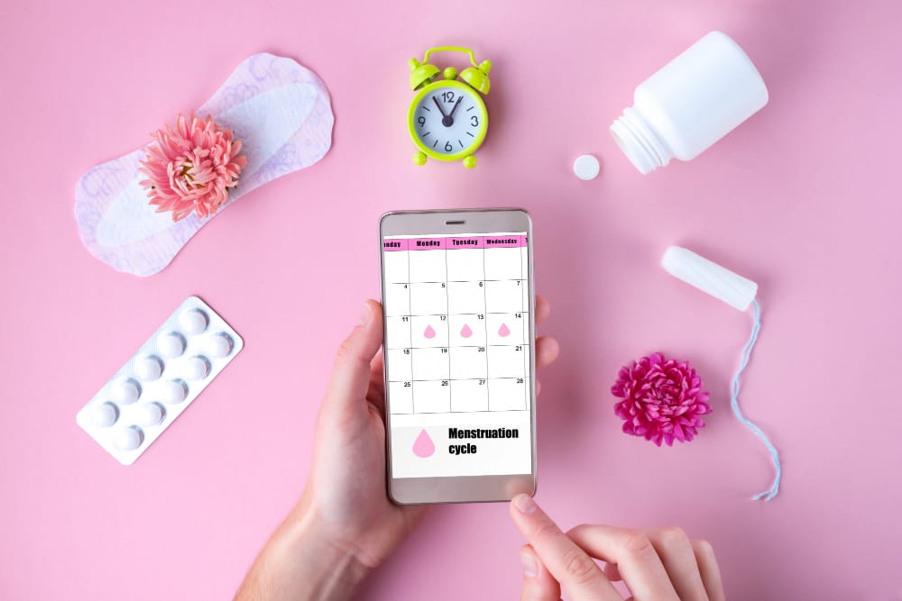 A woman is using an app on her phone to help track her menstruation cycle