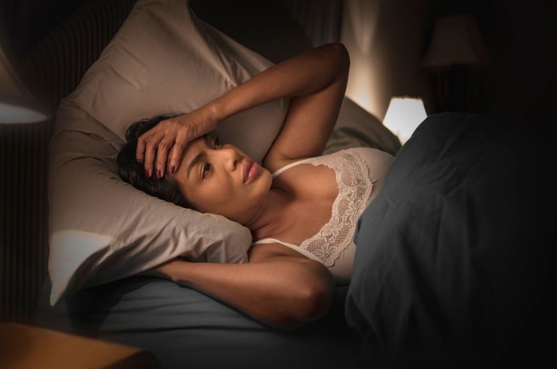 A woman who's in bed is having insomnia and can't fall asleep