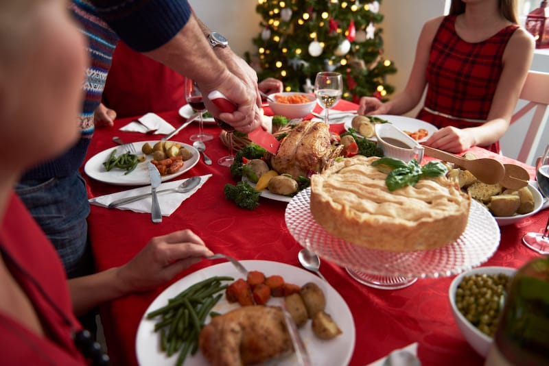A family is gathered around the Thanksgiving table ready to eat, this is also a time of the year when meat intake is higher and protein night sweats are more common.