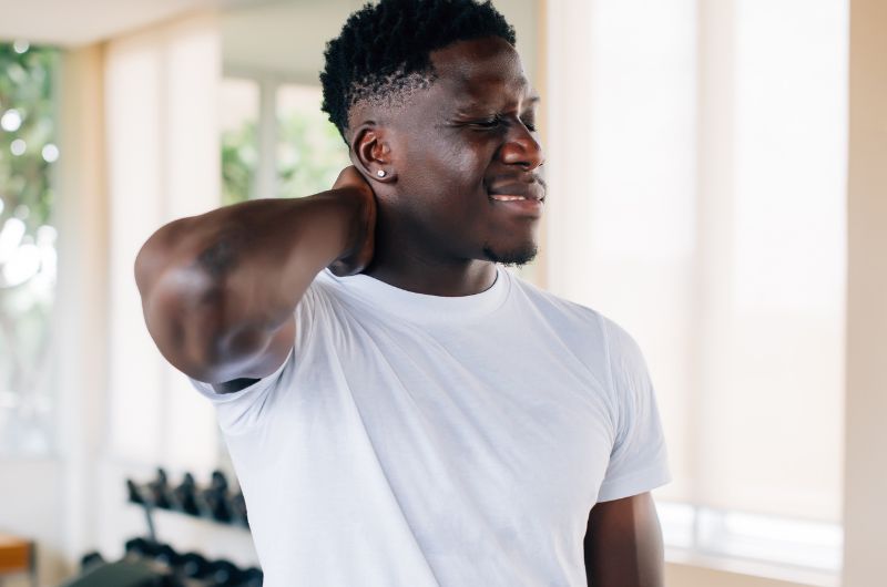 A fit man is stretching after doing some neck exercises