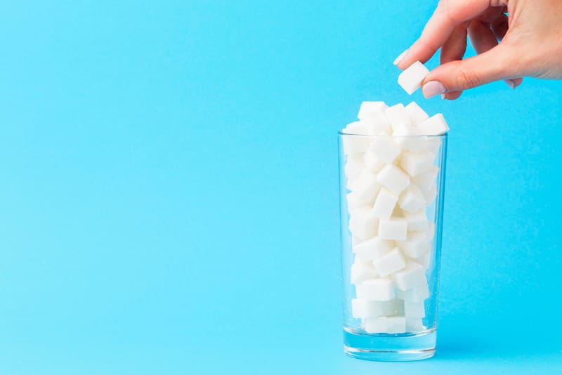 A glass of sugar cubes represents excess daily sugar consumption