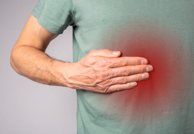 A middle-aged man is having pain discomfort from around his pancreas area