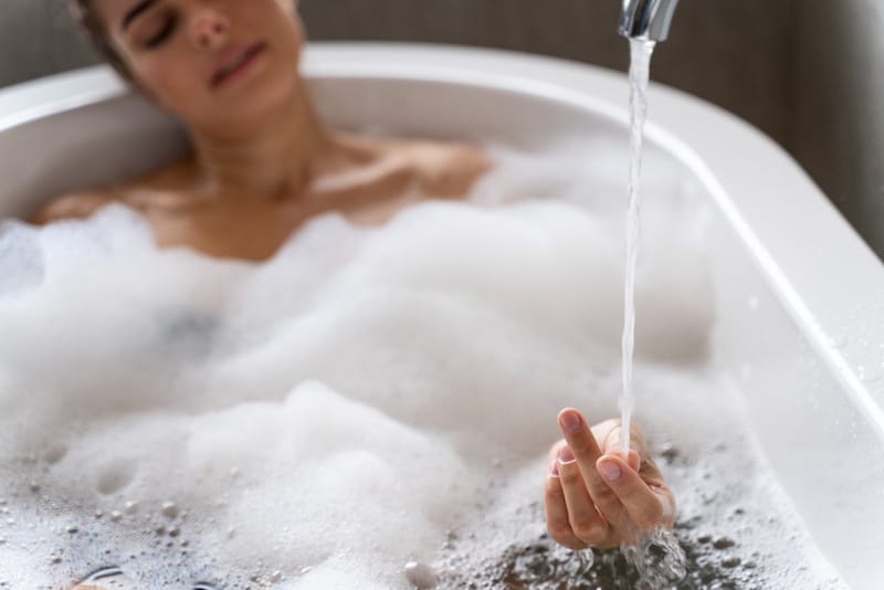 A woman is having a bath with baking soda in the bath water, to help with her anxiety.