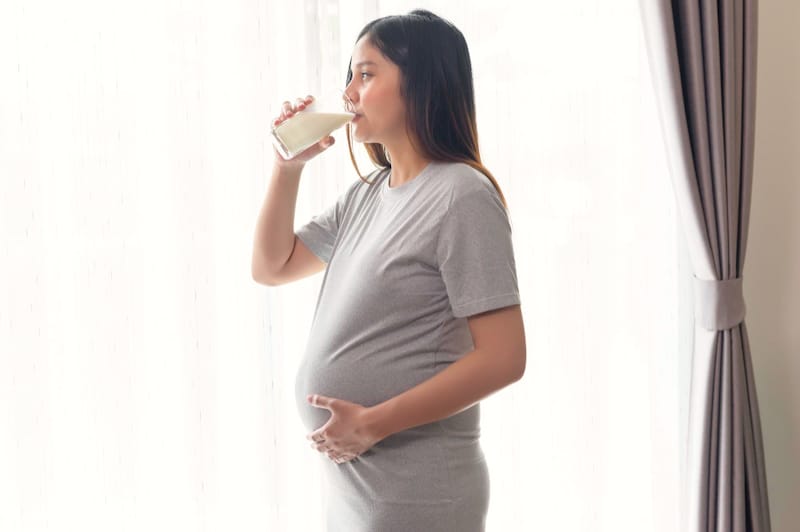 A pregnant woman is drinking soy milk to get a clean source of protein for her daily intake