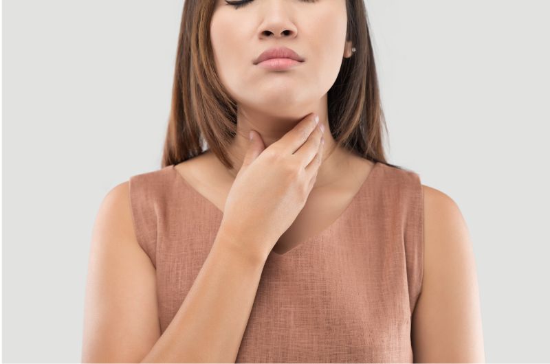 A woman with Xerostomia is trying to relieve her dry throat