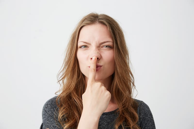 A woman is touching her nose because it's cold