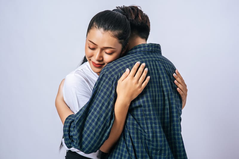 A young man is hugging his anxious girlfriend to help her feel safe and accepted in the moment