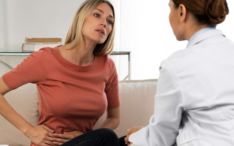 A woman visits the doctor after gallbladder surgery to get treated for her abdominal pain.
