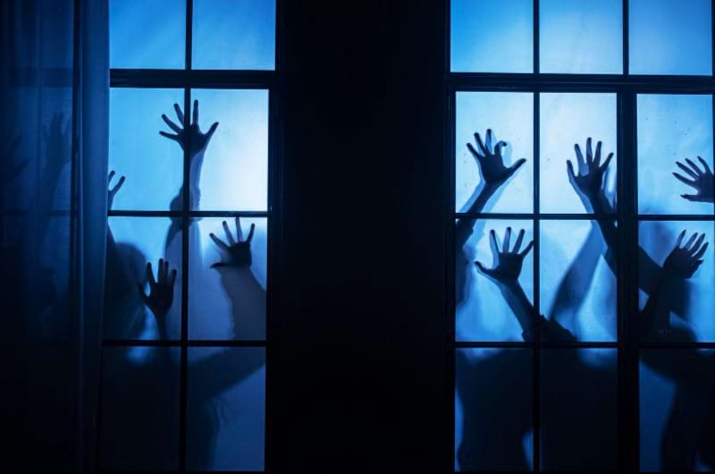 Various hands on the window in the middle of the night depict nightmares people with anxiety might have.