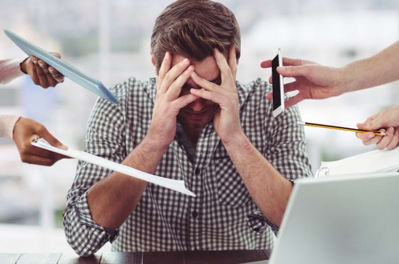 A young adult professional feels stressed due to several pending tasks and over workload.
