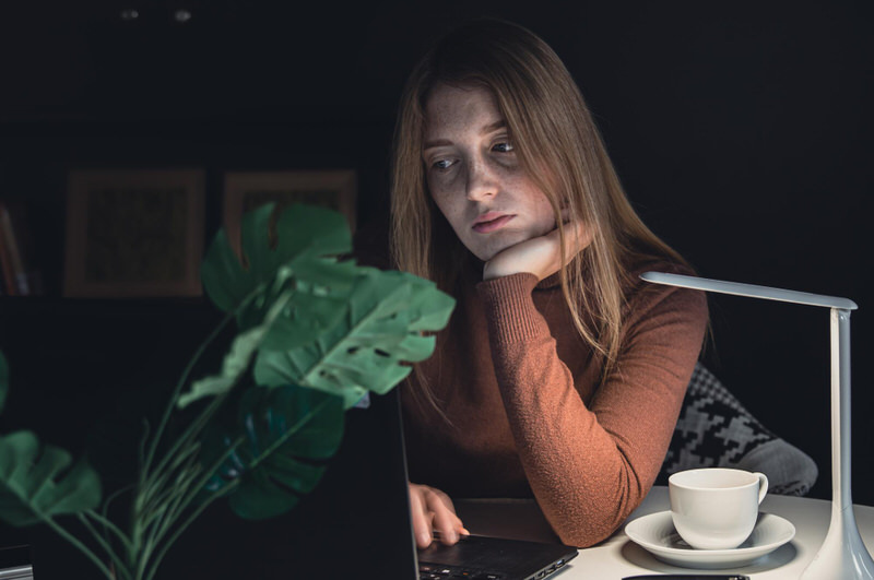 A young woman looks noticeably anxious after having some coffee