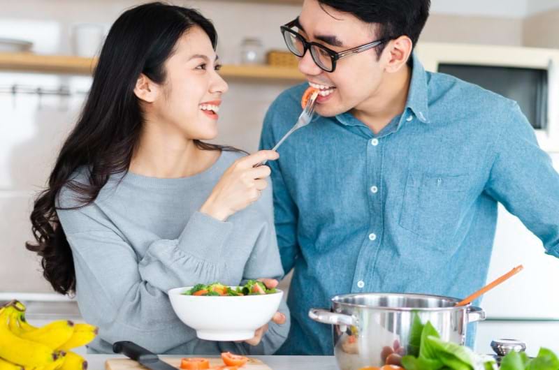 A couple is feeding each other healthy food to boost their fertility rate.