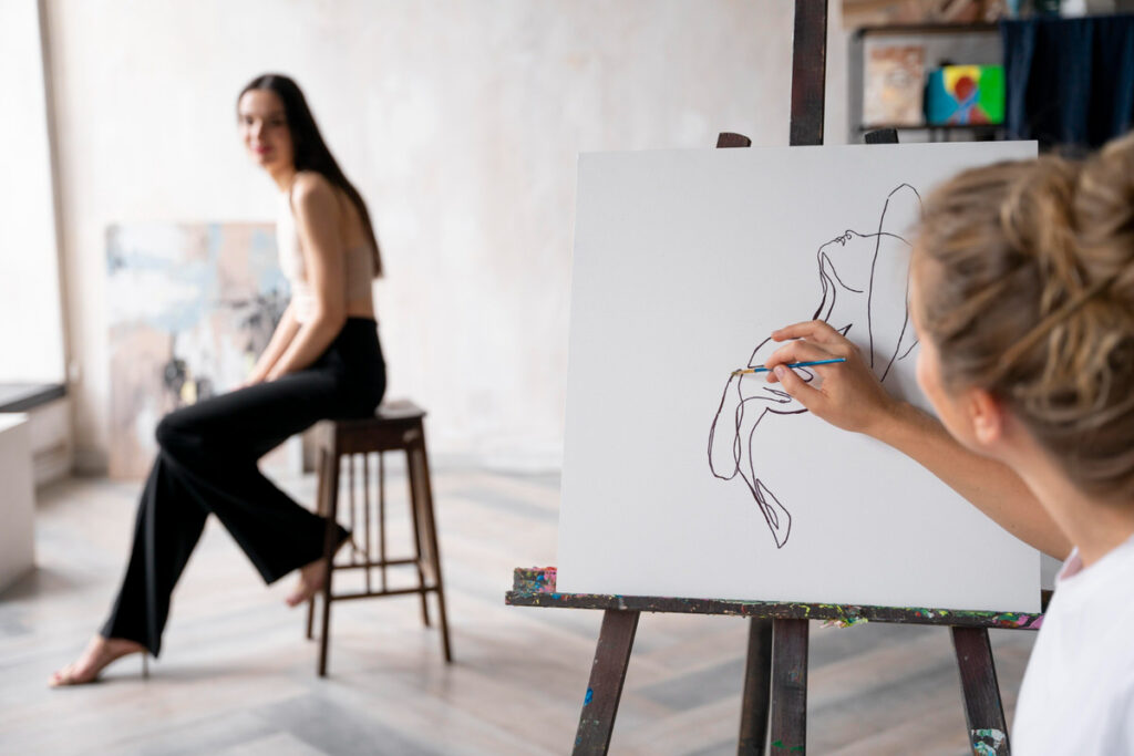A young woman is painting a live model for her art class