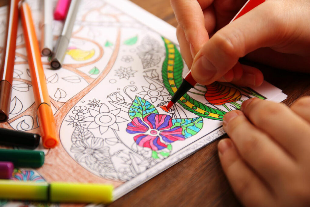 A person is using a coloring marker to color in paper