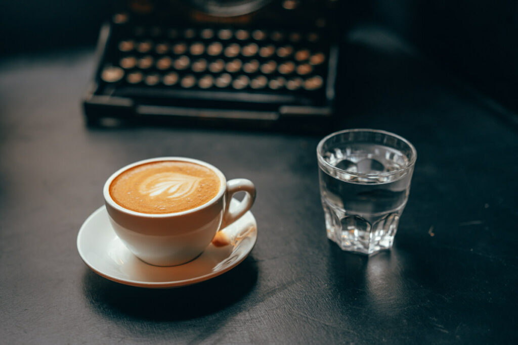 A cup of espresso next to a cup of water