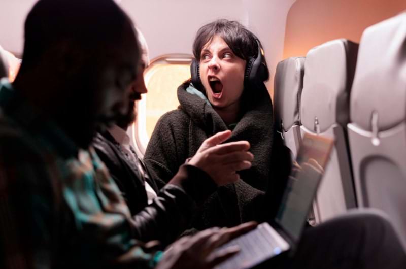 A woman panicking mid-flight and having an anxiety attack about flying in an airplane.