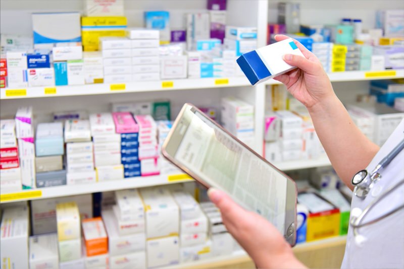 A pharmacist is filing a patient prescription through his tablet.