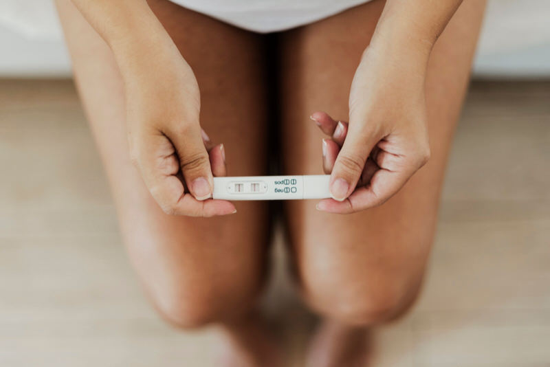 A young woman is waiting for her results after taking a pregnancy test at home.