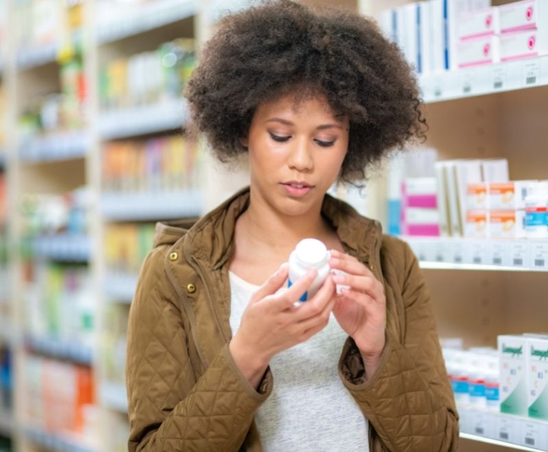 A woman is reading her medicine label to avoid overdosing