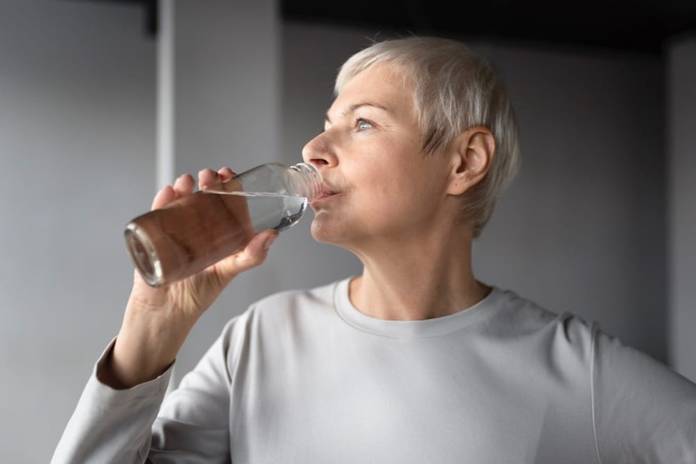 A woman who recently quit smoking is drinking lots of water to help reduce the phlegm in her throat.