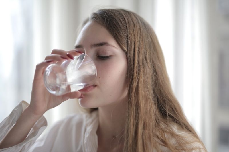 A young woman is drinking lots of water to flush out Bactrim from her system