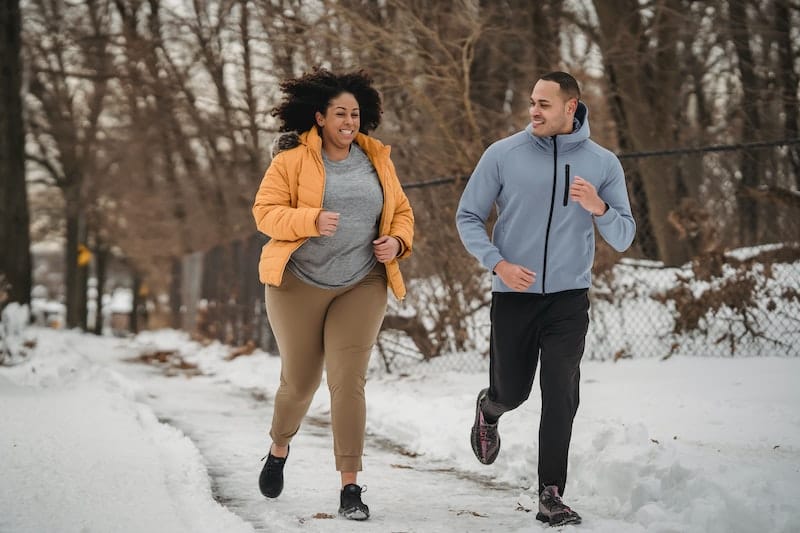 A couple are running together outside to stay on track with their weight loss goals