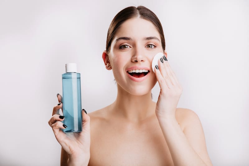 A woman is using a water-based toner during her skincare routine