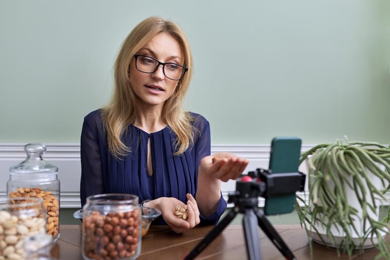 A female doctor is making a short video on how to eat high-fiber foods (like nuts, berries, and lentils) when taking the antibiotics Doxycycline Monohydrate